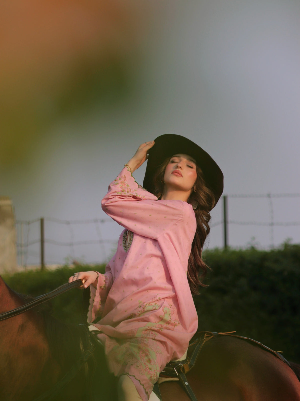 Model wearing a blush pink CAIRO luxury pret look on horseback